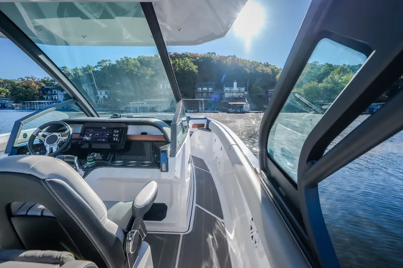 Slide: The Image of Interior view of 2026 Monterey Elite 30 OB boat, featuring modern dashboard and scenic lake backdrop. - 43