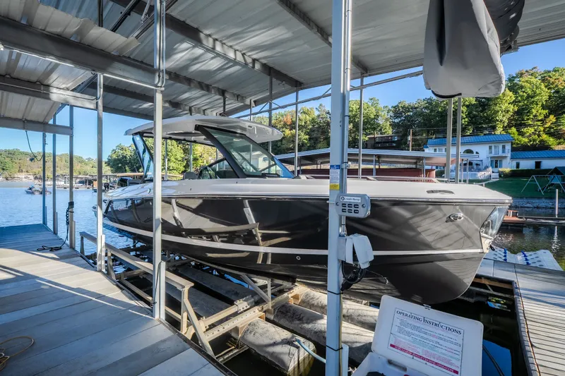 Slide: The Image of 2026 Monterey Elite 30 OB boat docked in a marina under a covered structure. - 75