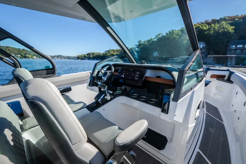 Slide: The Image of 2026 Monterey Elite 30 OB boat interior with modern dashboard and scenic lake view. - 25