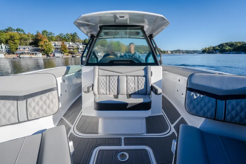 Slide: The Image of 2026 Monterey Elite 30 OB boat interior with luxurious seating on a serene lake. - 52