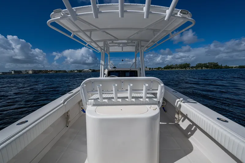 Slide: The Image of 2004 Jupiter 31 Cuddy boat on water, featuring spacious deck and rod holders. - 12