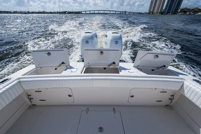 Slide: The Image of 2004 Jupiter 31 Cuddy boat with open storage compartments, cruising on water. - 14
