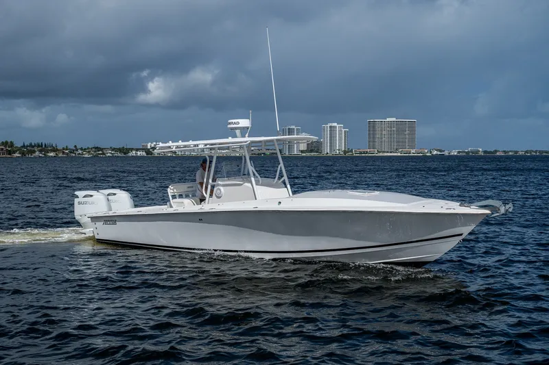 Slide: The Image of 2004 Jupiter 31 Cuddy boat cruising on water with city skyline in background. - 17
