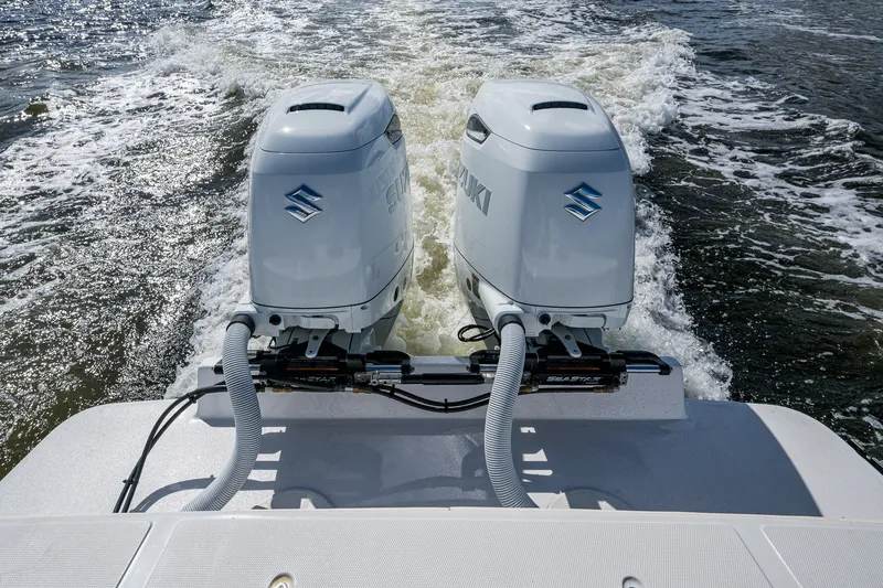 Slide: The Image of Twin Suzuki outboard engines on a 2004 Jupiter 31 Cuddy boat in motion. - 16