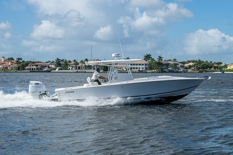 Slide: The Image of 2004 Jupiter 31 Cuddy boat cruising on water with scenic waterfront homes in background. - 19