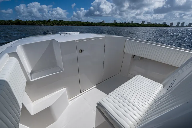 Slide: The Image of 2004 Jupiter 31 Cuddy boat interior with white seating, on a sunny day by the water. - 5