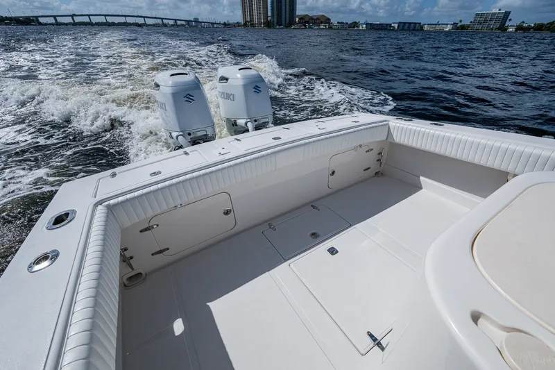 Slide: The Image of 2004 Jupiter 31 Cuddy boat with twin Suzuki engines cruising on open water. - 15