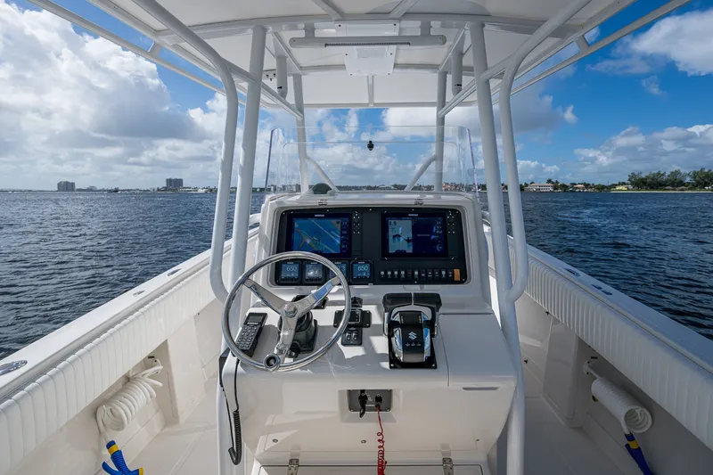 Slide: The Image of 2004 Jupiter 31 Cuddy boat helm with navigation screens on open water. - 10