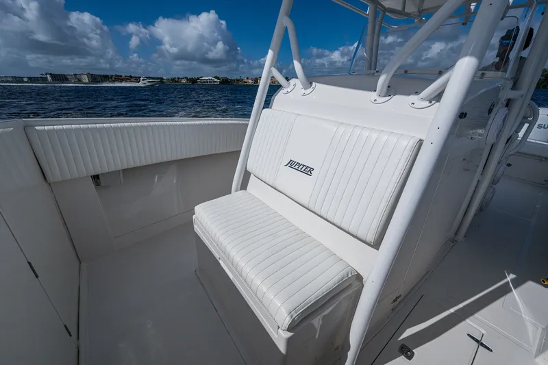 Slide: The Image of 2004 Jupiter 31 Cuddy boat interior with white seating, ocean view, and blue sky. - 8