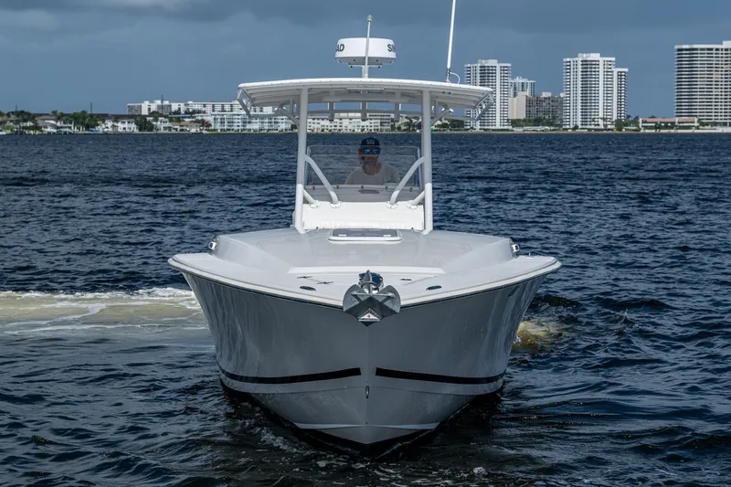 Slide: The Image of 2004 Jupiter 31 Cuddy boat cruising on water with city skyline in background. - 3