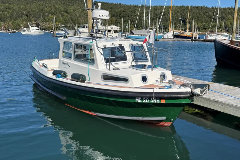 The Image of Mitchell Sea Angler 2002 boat docked in a marina with scenic background. - 0