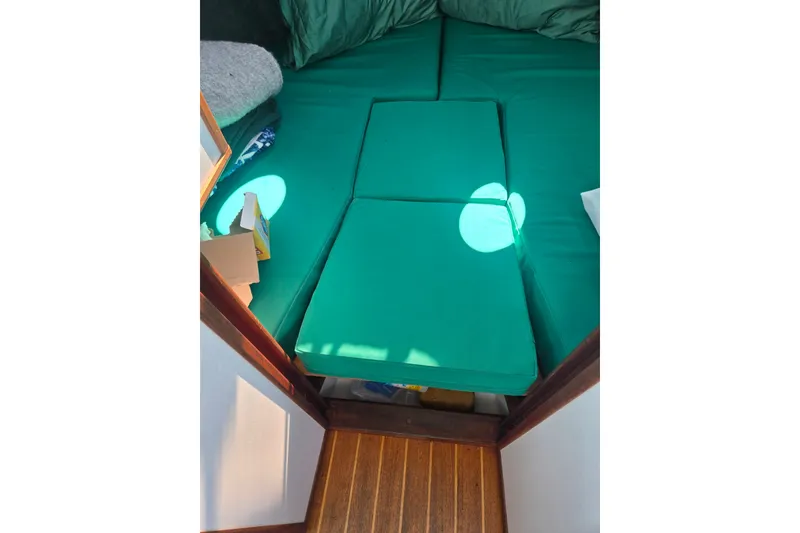 Slide: The Image of Cozy cabin interior with green cushions on a Mitchell Sea Angler 2002 boat. - 14
