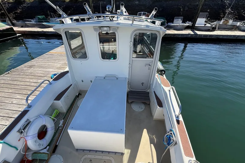 Slide: The Image of Mitchell Sea Angler 2002 boat docked, featuring spacious deck and fishing equipment. - 8