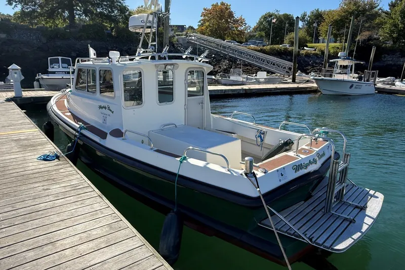 Slide: The Image of Mitchell Sea Angler 2002 boat docked at a marina, featuring a spacious deck and cabin. - 4