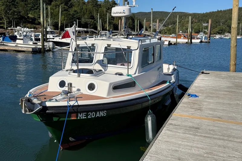 Slide: The Image of 2002 Mitchell Sea Angler boat docked at a marina with scenic forest backdrop. - 2