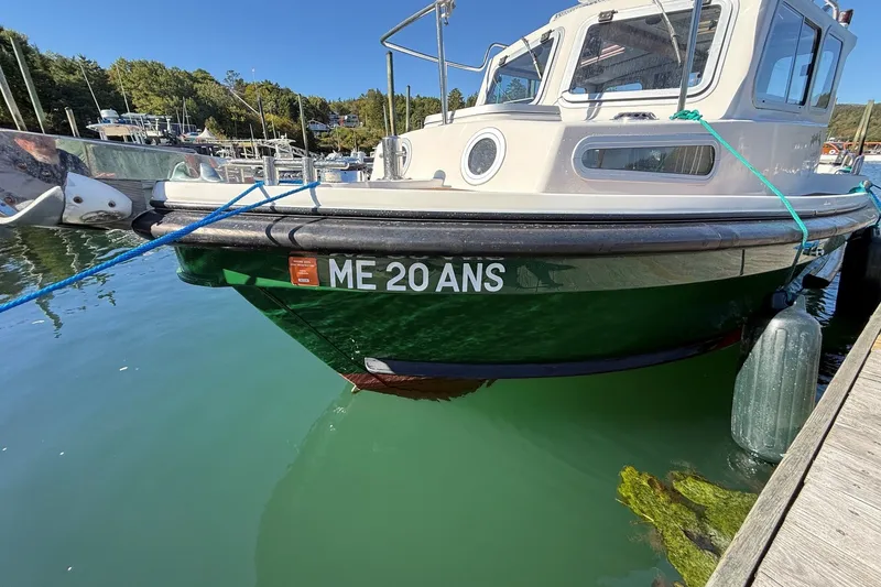 Slide: The Image of Mitchell Sea Angler 2002 boat docked, green hull, clear sky, marina background. - 7