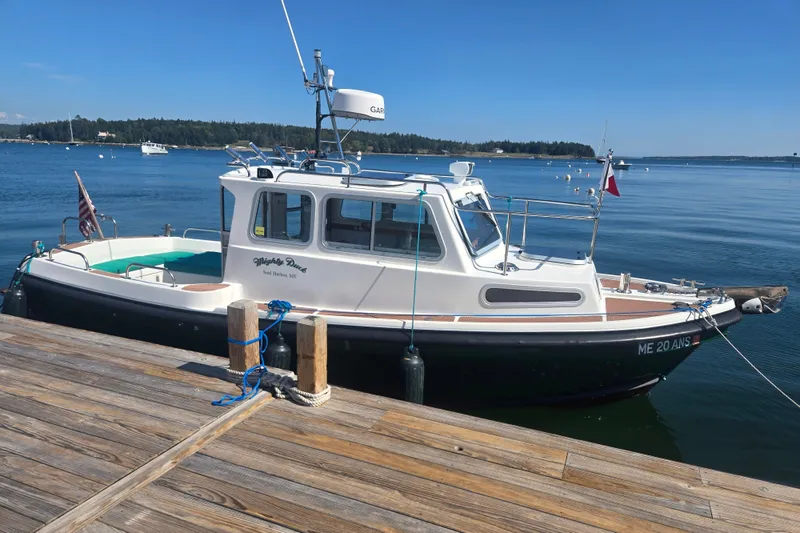 Slide: The Image of Mitchell Sea Angler 2002 boat docked on calm water with clear blue sky. - 6