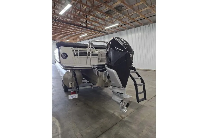 Slide: The Image of 2025 Sylvan G3 CLZ DC pontoon boat with powerful outboard motor in a warehouse. - 6