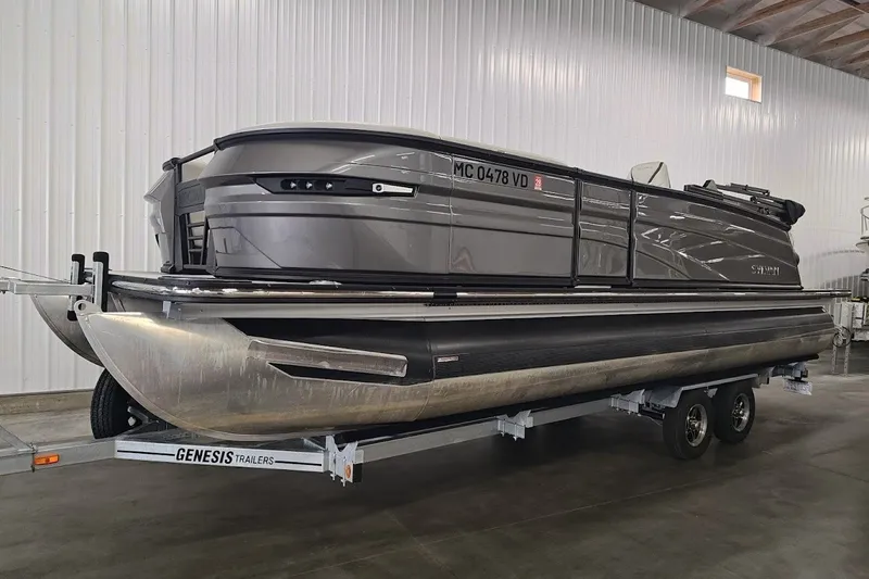 Slide: The Image of 2025 Sylvan G3 CLZ DC pontoon boat on Genesis trailer in indoor storage. - 1
