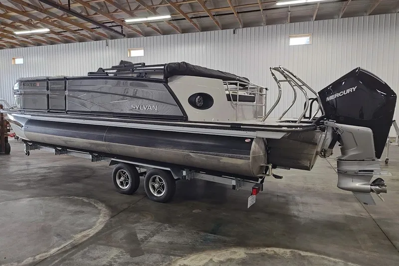 Slide: The Image of 2025 Sylvan G3 CLZ DC pontoon boat with Mercury outboard in a warehouse setting. - 2