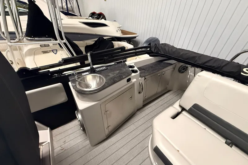 Slide: The Image of Interior of 2025 Sylvan G3 CLZ DC boat featuring a compact kitchenette and seating area. - 15