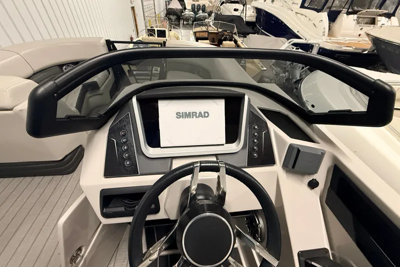 Slide: The Image of 2025 Sylvan G3 CLZ DC boat dashboard with Simrad display and steering wheel. - 24