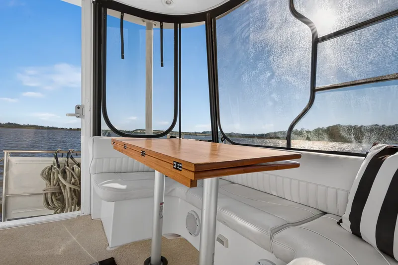 Slide: The Image of 2003 Cruisers Yachts 4450 Express Motoryacht interior with seating and table, overlooking water. - 12