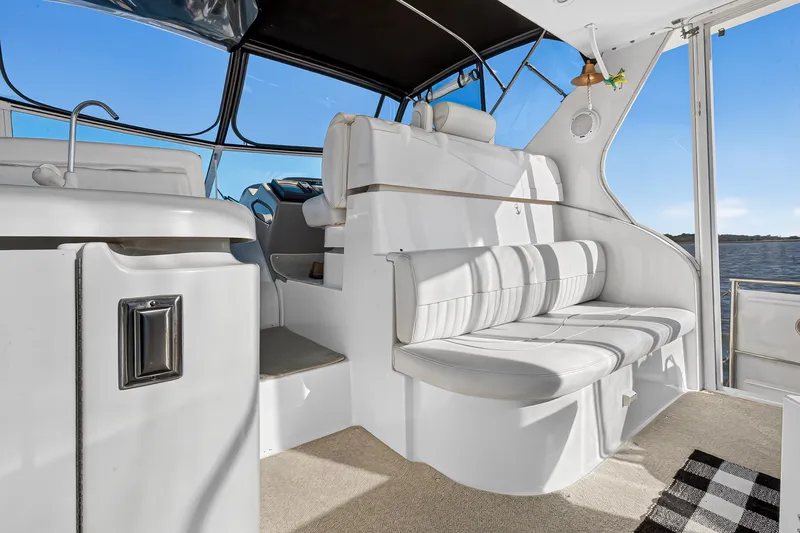 Slide: The Image of Luxurious interior of 2003 Cruisers Yachts 4450 Express Motoryacht with white seating and scenic view. - 13