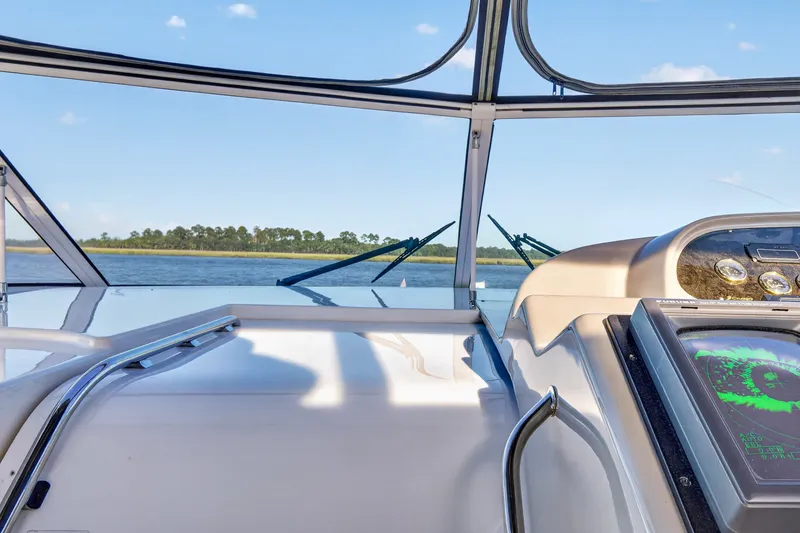 Slide: The Image of 2003 Cruisers Yachts 4450 Express Motoryacht helm view with clear skies and water. - 19
