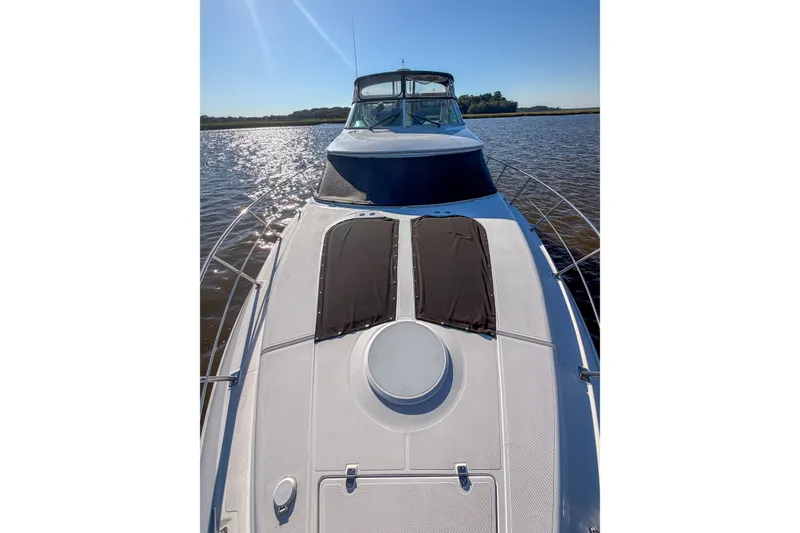 Slide: The Image of 2003 Cruisers Yachts 4450 Express Motoryacht on calm water, sunny day. - 25
