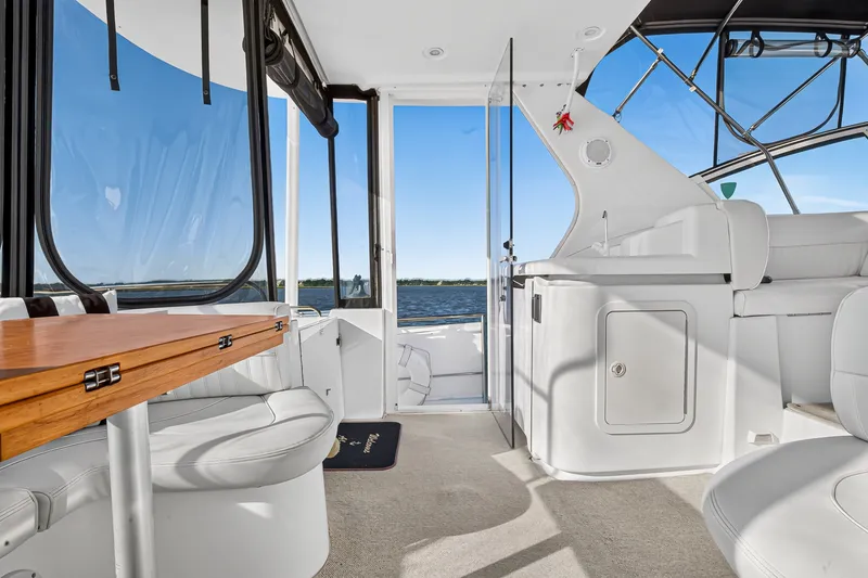 Slide: The Image of 2003 Cruisers Yachts 4450 Express Motoryacht interior with seating and table, overlooking water. - 9