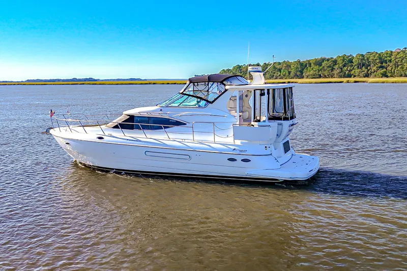 Slide: The Image of 2003 Cruisers Yachts 4450 Express Motoryacht cruising on a serene river. - 3