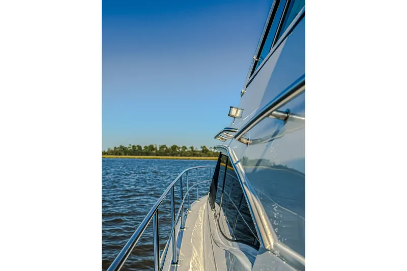 Slide: The Image of Side view of 2003 Cruisers Yachts 4450 Express Motoryacht on calm water. - 23