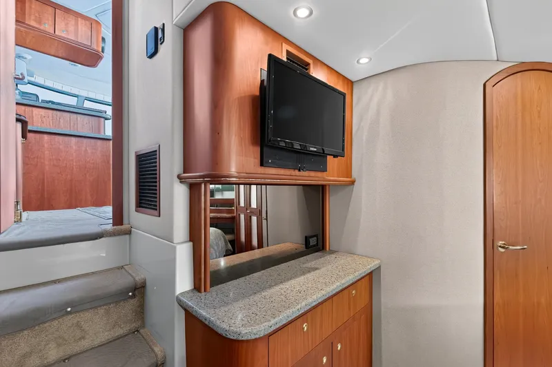 Slide: The Image of Interior of 2003 Cruisers Yachts 4450 Express Motoryacht with TV and wooden cabinetry. - 48