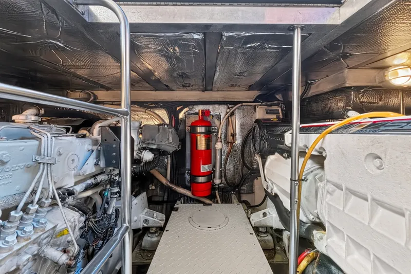 Slide: The Image of Engine room of 2003 Cruisers Yachts 4450 Express Motoryacht with visible machinery and fire extinguisher. - 63