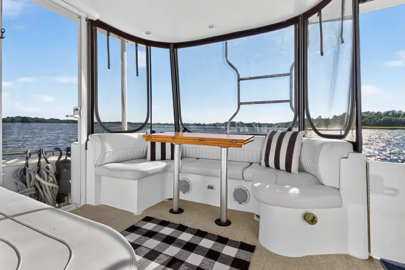 Slide: The Image of 2003 Cruisers Yachts 4450 Express Motoryacht interior with seating and table, overlooking water. - 10