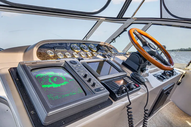 Slide: The Image of Helm of 2003 Cruisers Yachts 4450 Express Motoryacht with navigation equipment and wooden steering wheel. - 18