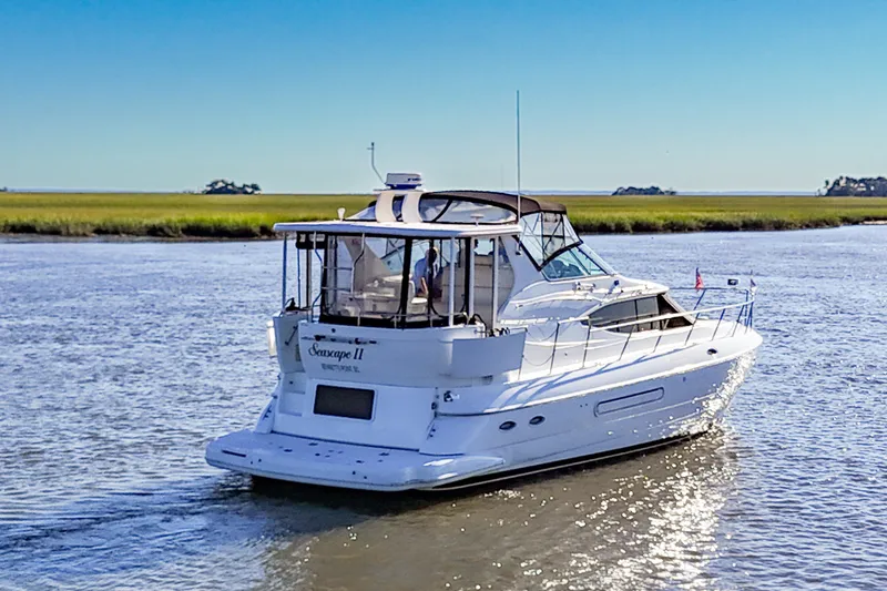 Slide: The Image of 2003 Cruisers Yachts 4450 Express Motoryacht cruising on a serene waterway. - 2