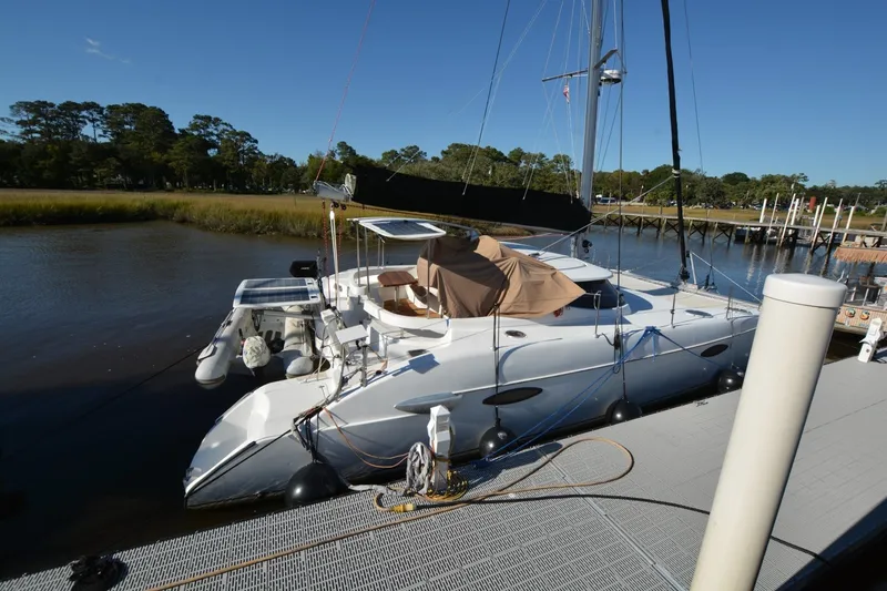 Slide: The Image of 2006 Fountaine Pajot LAVEZZI 40 catamaran docked by a serene riverbank. - 3