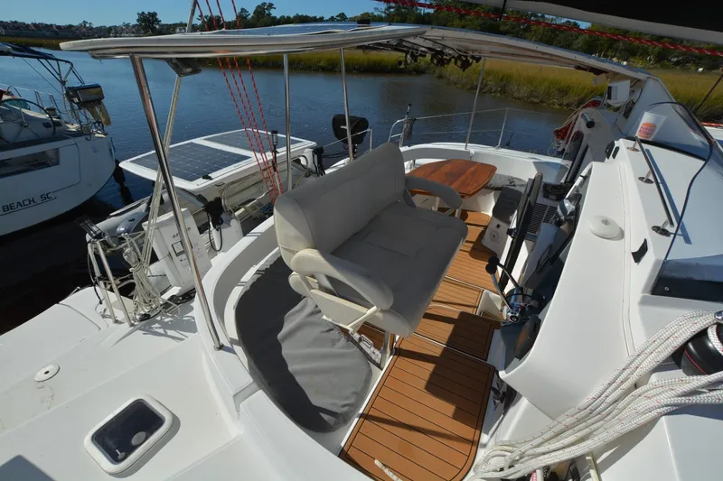 Slide: The Image of 2006 Fountaine Pajot LAVEZZI 40 catamaran cockpit with seating and helm, docked by water. - 14