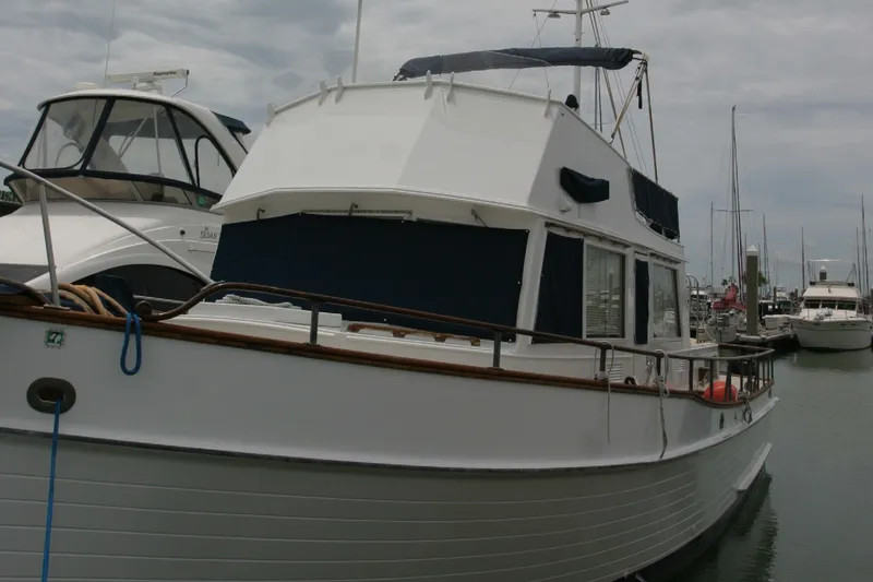 Slide: The Image of 1979 Grand Banks 42 Classic yacht docked at a marina under cloudy skies. - 1
