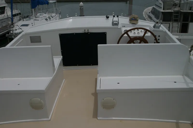 Slide: The Image of 1979 Grand Banks 42 Classic yacht helm with wooden steering wheel and seating. - 5