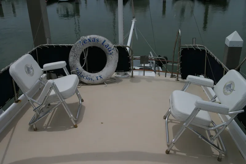 Slide: The Image of 1979 Grand Banks 42 Classic yacht deck with chairs and life preserver, docked in Palacios, TX. - 6