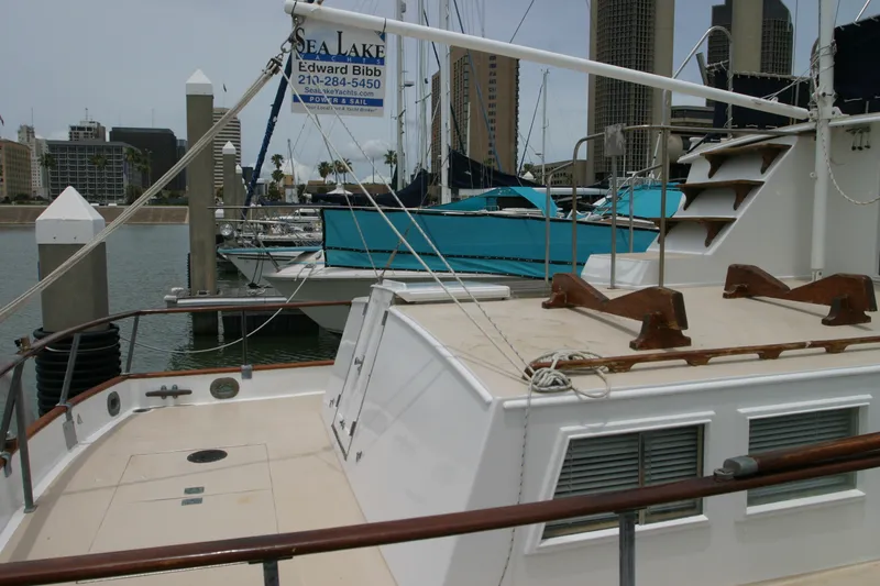 Slide: The Image of 1979 Grand Banks 42 Classic yacht docked at marina with city skyline backdrop. - 2