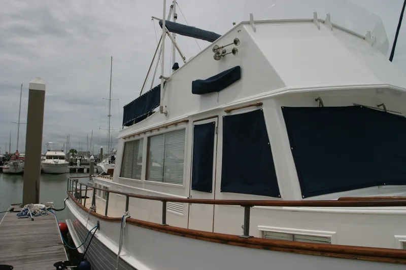 Slide: The Image of 1979 Grand Banks 42 Classic yacht docked at a marina, featuring blue canvas covers. - 7