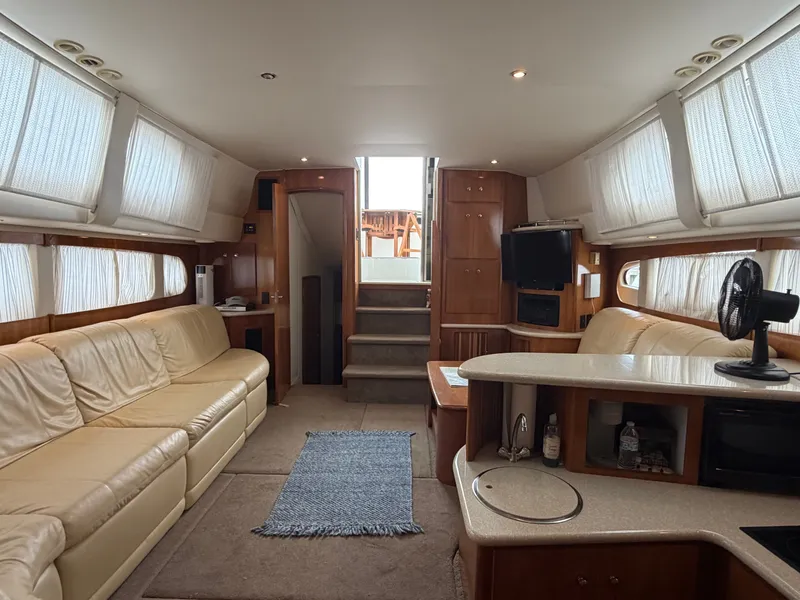 Slide: The Image of Interior of the 2002 Carver 396 Aft Cabin Motor Yacht with beige leather sofas and kitchenette. - 20