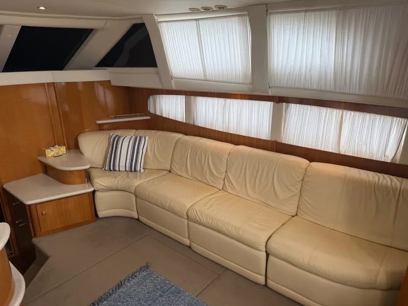 Slide: The Image of Interior of the 2002 Carver 396 Aft Cabin Motor Yacht with beige leather sofa and windows. - 16