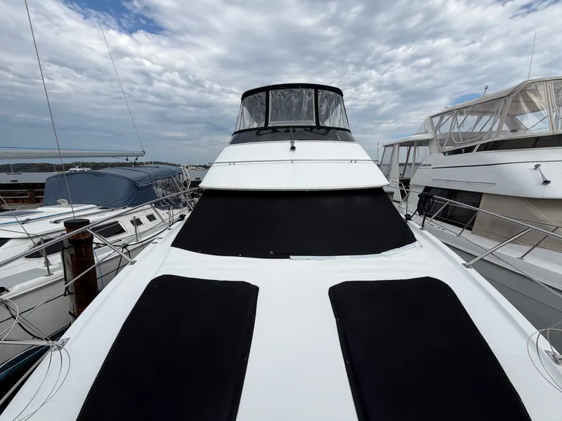 Slide: The Image of The 2002 Carver 396 Aft Cabin Motor Yacht is docked, surrounded by other boats. - 34