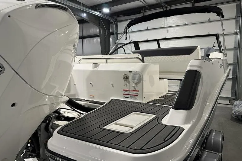 Slide: The Image of 2025 Bayliner Trophy T22SC boat in a garage, showcasing rear deck and engine. - 6
