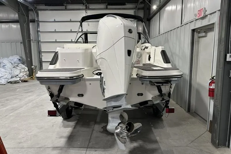 Slide: The Image of 2025 Bayliner Trophy T22SC boat in a garage, showcasing its powerful outboard motor. - 3